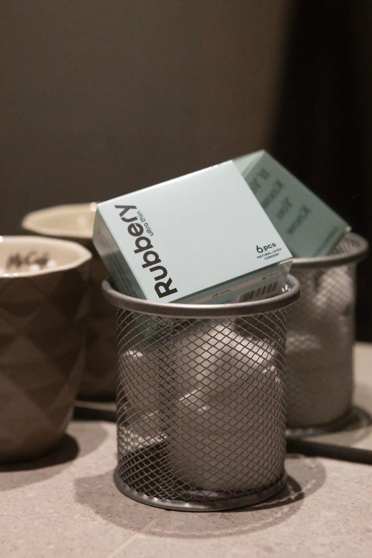 Box of Rubbery products in a mesh container on a neutral background